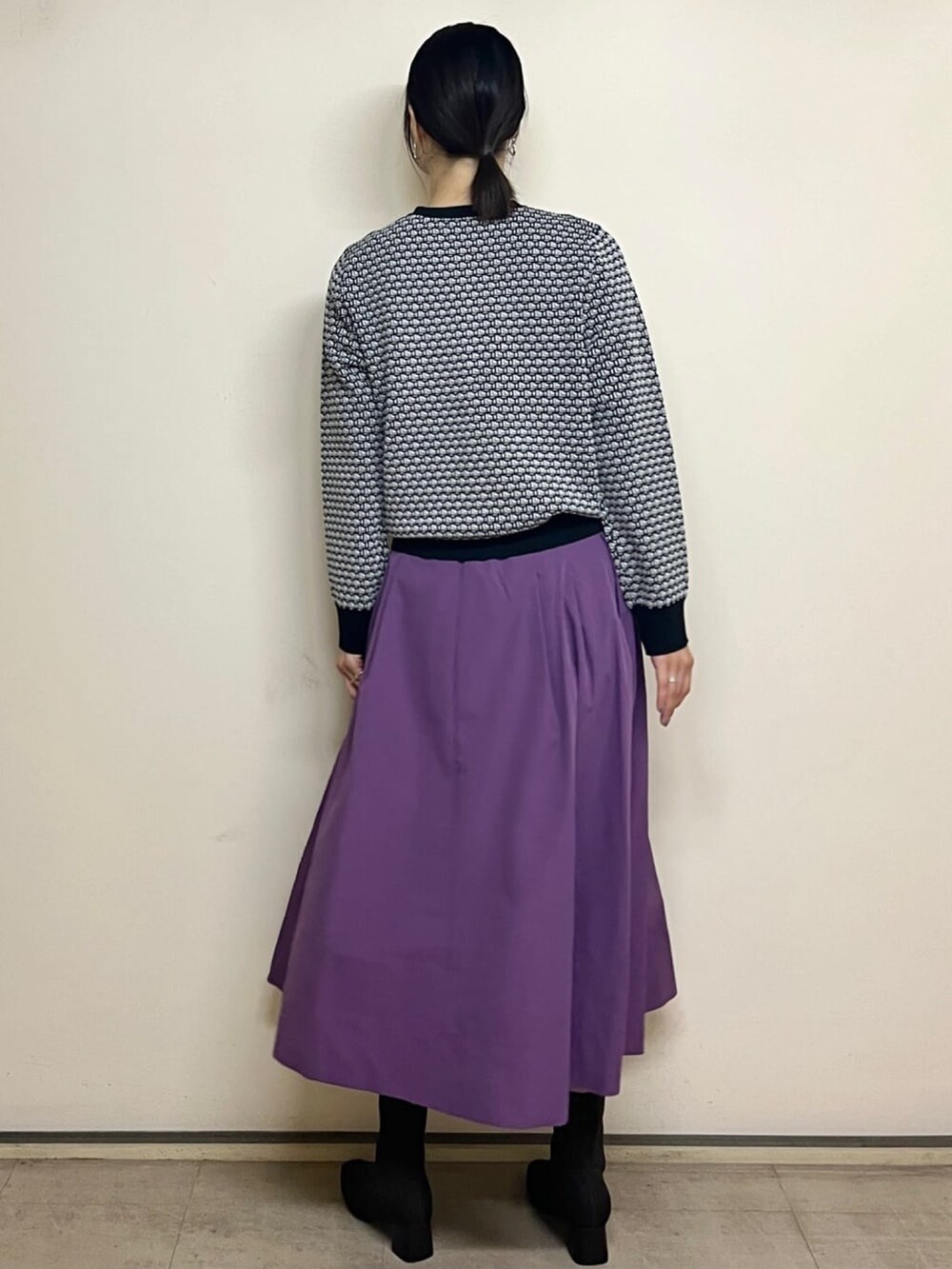ホワイト系のカーディガン/ボレロ、パープル系のスカート、ブラック系のブーツを着用したレディースの夏コーディネートの4枚目の写真