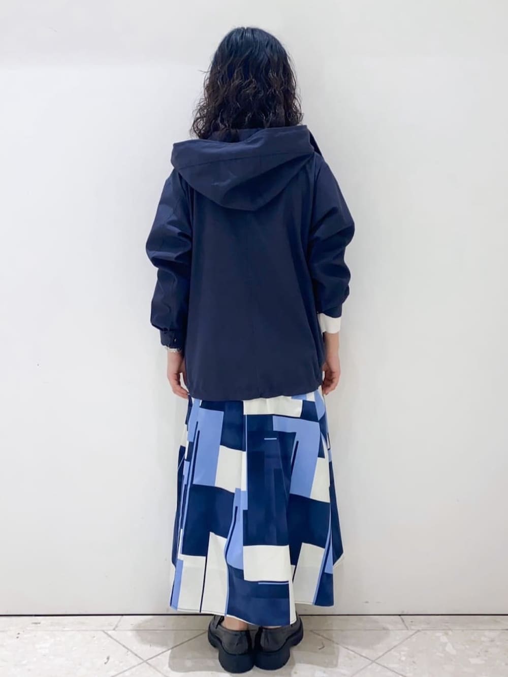 ブルー系のブルゾン、ブルー系のスカート、ホワイト系のニット/セーターを着用したレディースの春コーディネートの3枚目の写真