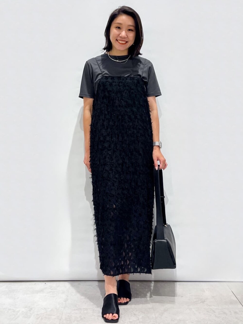 ブラック系のサンダル、ブラック系のショルダーバッグ、ブラック系のワンピースを着用したレディースの夏コーディネートの5枚目の写真