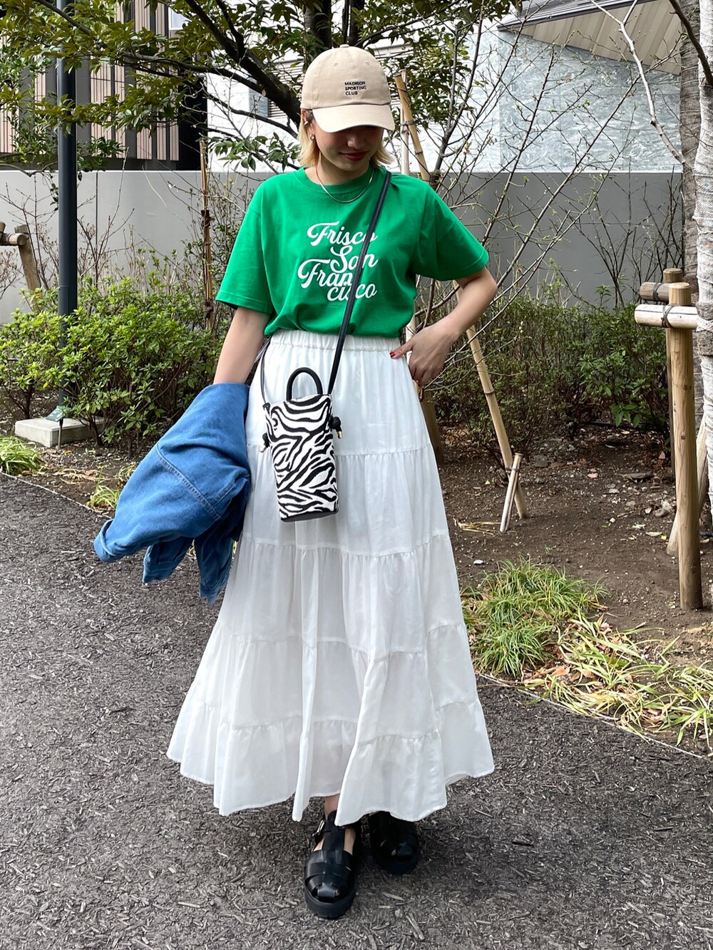 ブラック系のサンダル、ホワイト系のスカート、ホワイト系のショルダーバッグを着用したレディースの春コーディネートの2枚目の写真