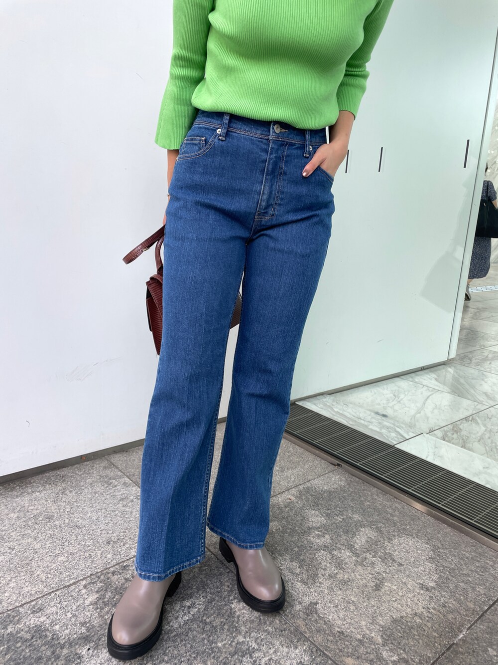 グリーン系のニット/セーター、ブルー系のその他パンツ、ブラウン系のショルダーバッグを着用したレディースの秋コーディネートの4枚目の写真