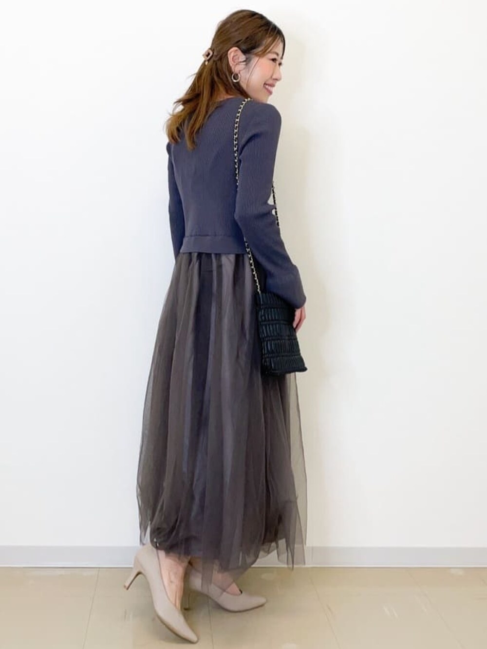 ブラック系のワンピース、ブラック系のショルダーバッグ、ベージュ系のパンプスを着用したレディースの春コーディネートの2枚目の写真