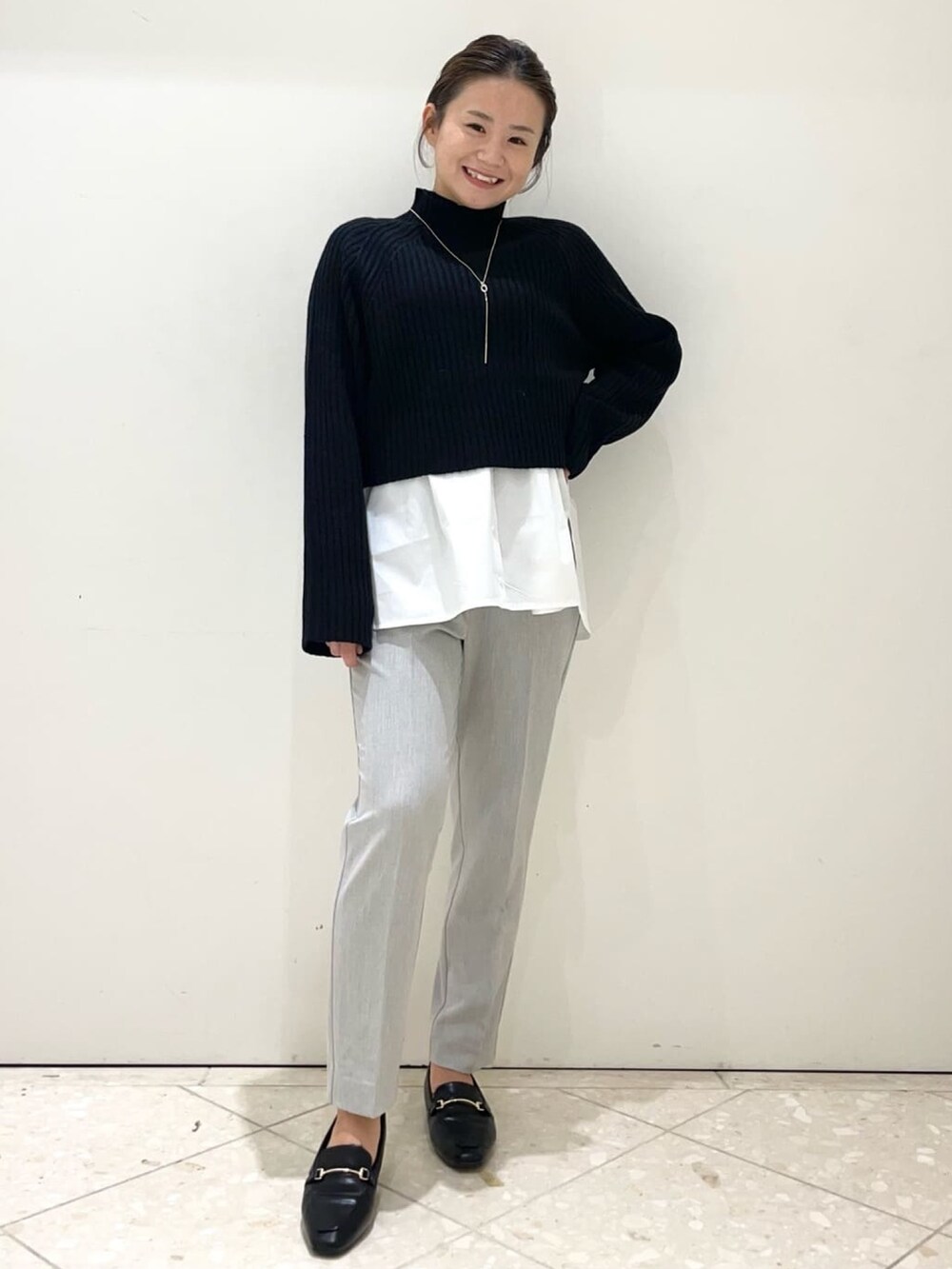 ブラック系のノーカラーコート、グレー系のその他パンツ、ブラック系のパンプスを着用したレディースの冬コーディネートの5枚目の写真