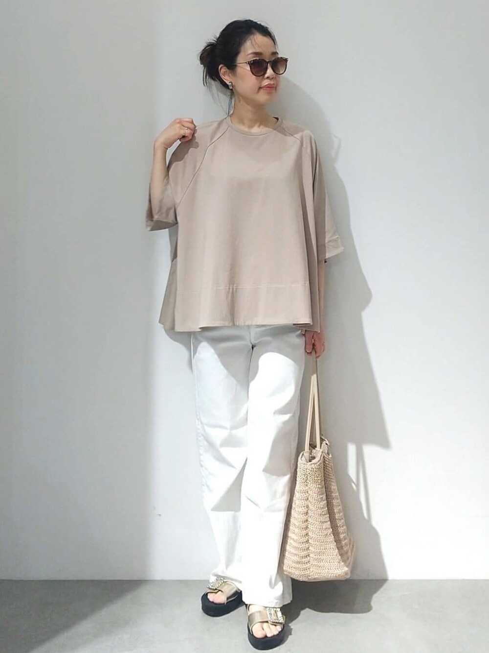 ベージュ系のTシャツ/カットソー、オレンジ系のカーディガン/ボレロ、ホワイト系のデニムパンツを着用したレディースの春コーディネートの6枚目の写真