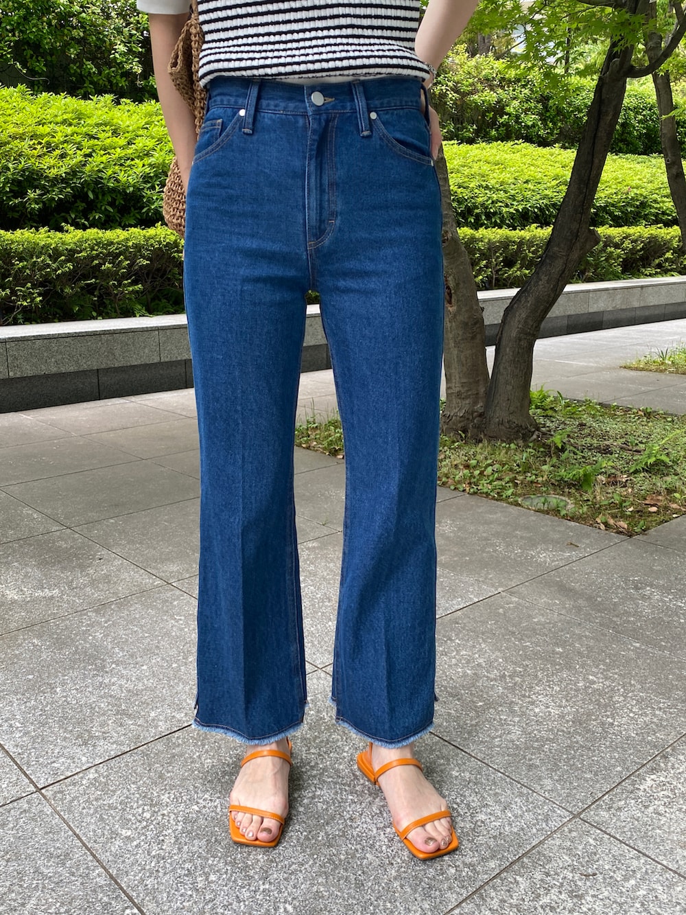 ホワイト系のニット/セーター、ブルー系のデニムパンツ、ベージュ系のトートバッグを着用したレディースの春コーディネートの3枚目の写真