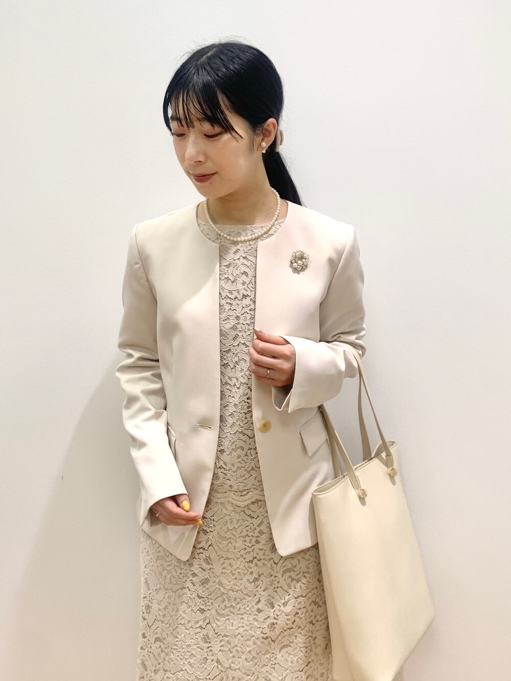 ベージュ系のノーカラージャケット、ベージュ系のシャツ/ブラウス、ベージュ系のスカートを着用したレディースの冬コーディネートの2枚目の写真