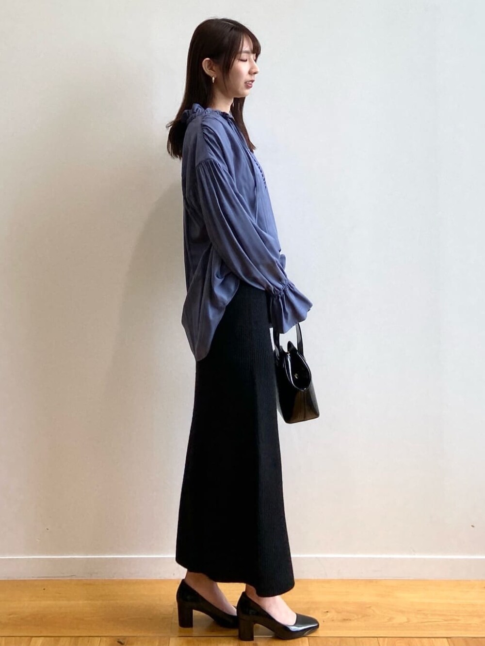 ブラック系のショルダーバッグ、ブルー系のシャツ/ブラウス、ブラック系のパンプスを着用したレディースの秋コーディネートの3枚目の写真
