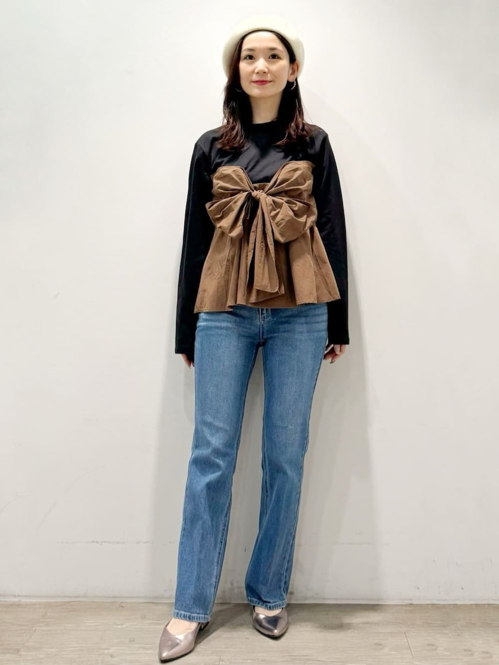 シルバー系のパンプス、ブルー系のデニムパンツ、ブラック系のTシャツ/カットソーを着用したレディースの秋コーディネートの3枚目の写真