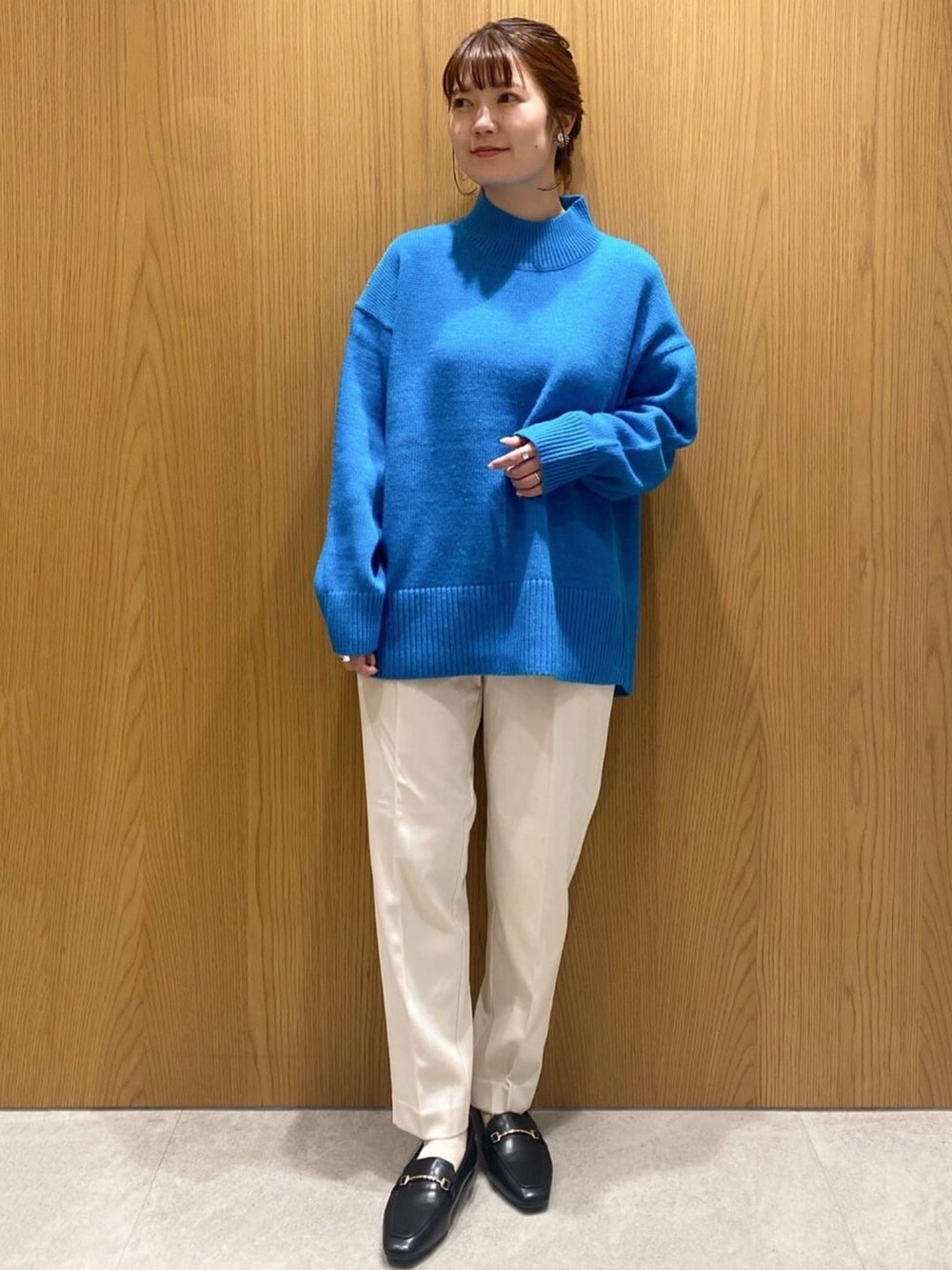 ブルー系のニット/セーター、ホワイト系のその他パンツ、ブラック系のパンプスを着用したレディースの秋コーディネートの4枚目の写真