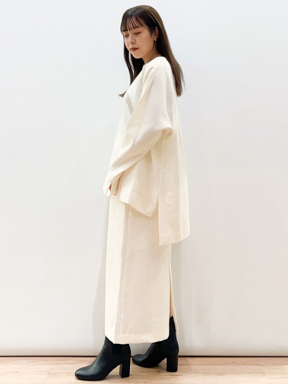 ホワイト系のシャツ/ブラウス、ホワイト系のスカート、ブラック系のショルダーバッグを着用したレディースの秋コーディネートの2枚目の写真