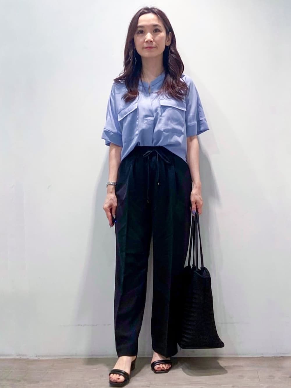 ブルー系のシャツ/ブラウス、ブラック系のその他パンツ、ブラック系のトートバッグを着用したレディースの春コーディネートの2枚目の写真