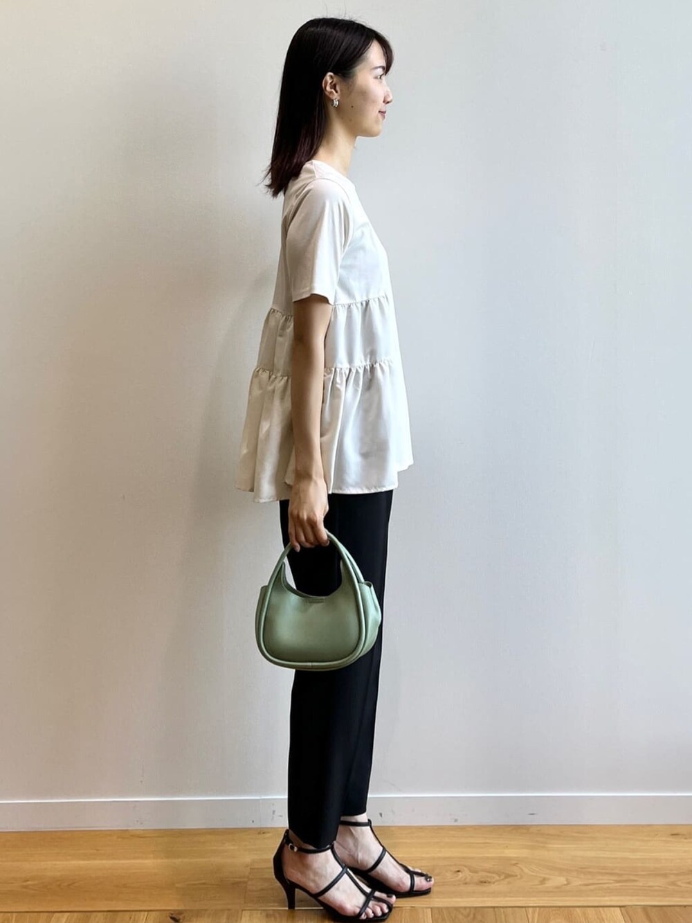 ホワイト系のTシャツ/カットソー、ブラック系のその他パンツ、ブラック系のサンダルを着用したレディースの秋コーディネートの2枚目の写真