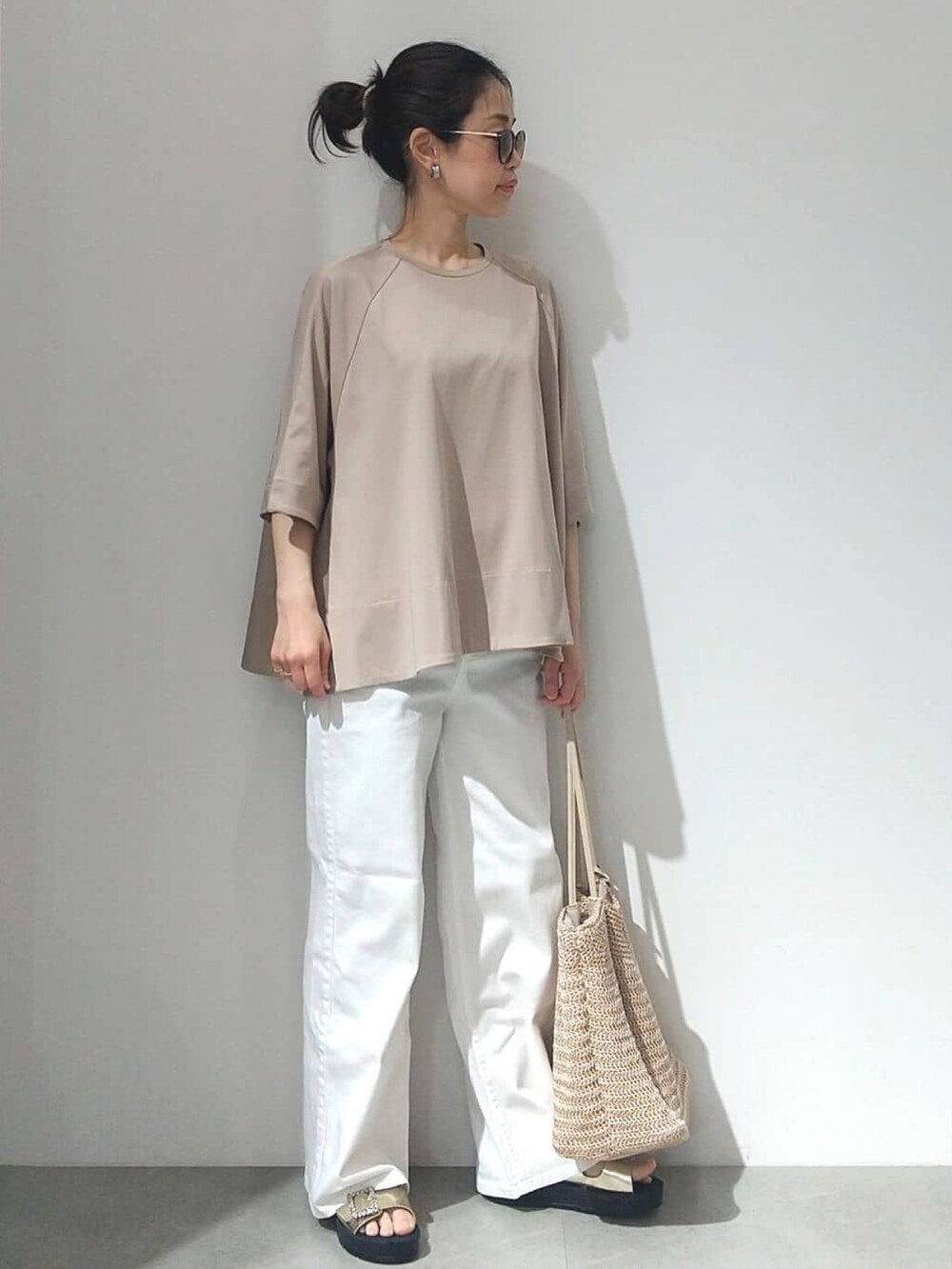 ベージュ系のTシャツ/カットソー、オレンジ系のカーディガン/ボレロ、ホワイト系のデニムパンツを着用したレディースの春コーディネートの9枚目の写真