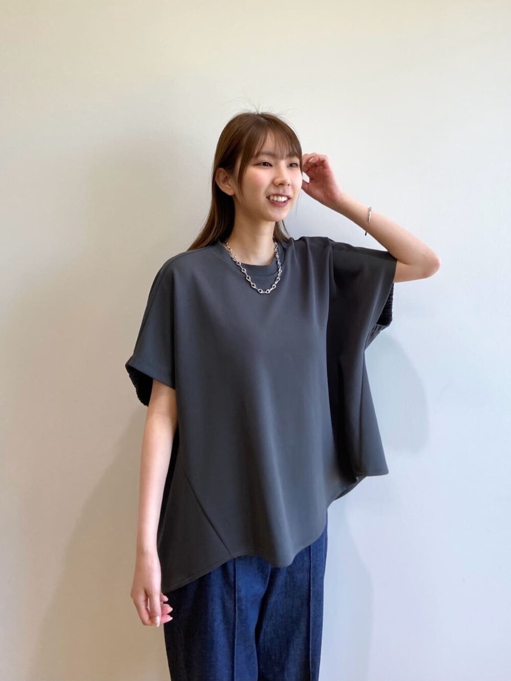 グレー系のTシャツ/カットソー、ブルー系のデニムパンツ、ブラック系のサンダルを着用したレディースの春コーディネートの7枚目の写真