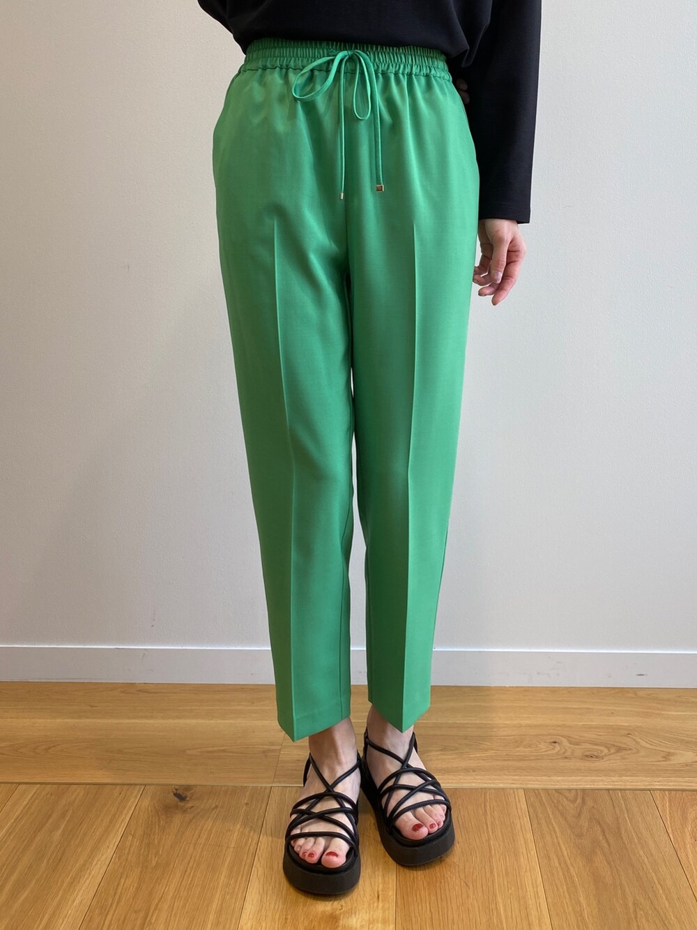 ブラック系のサンダル、グリーン系のその他パンツ、ベージュ系のトレンチコートを着用したレディースの春コーディネートの9枚目の写真