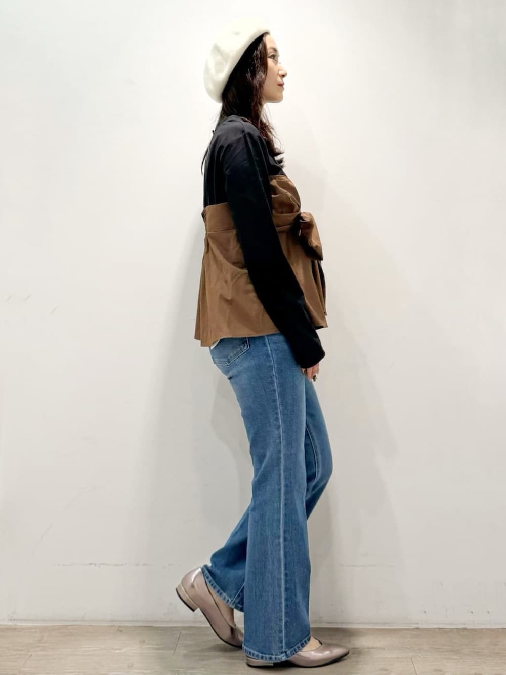 シルバー系のパンプス、ブルー系のデニムパンツ、ブラック系のTシャツ/カットソーを着用したレディースの秋コーディネートの4枚目の写真