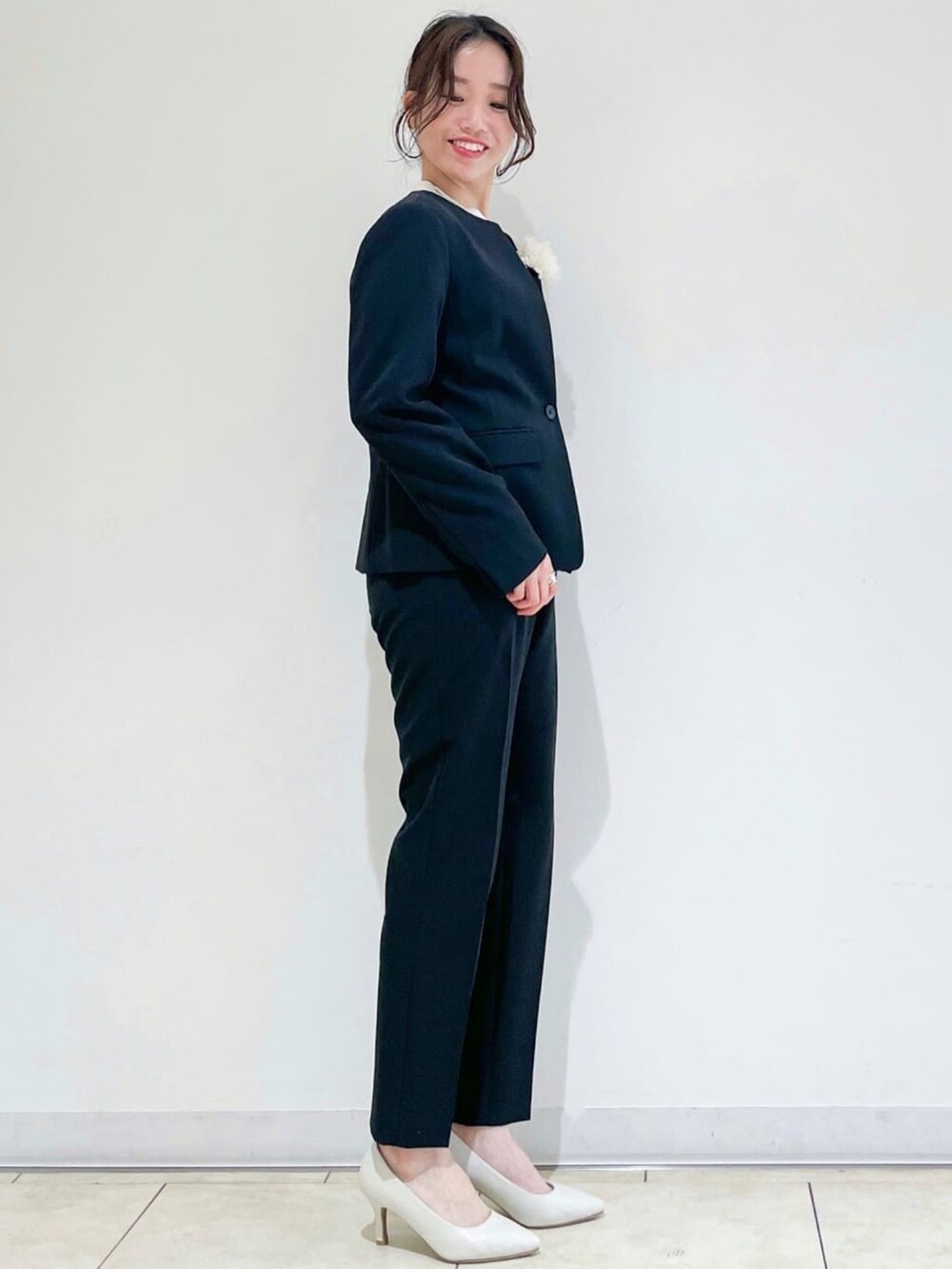 ブラック系のノーカラージャケット、ブラック系のその他パンツ、ホワイト系のトートバッグを着用したレディースの冬コーディネートの2枚目の写真