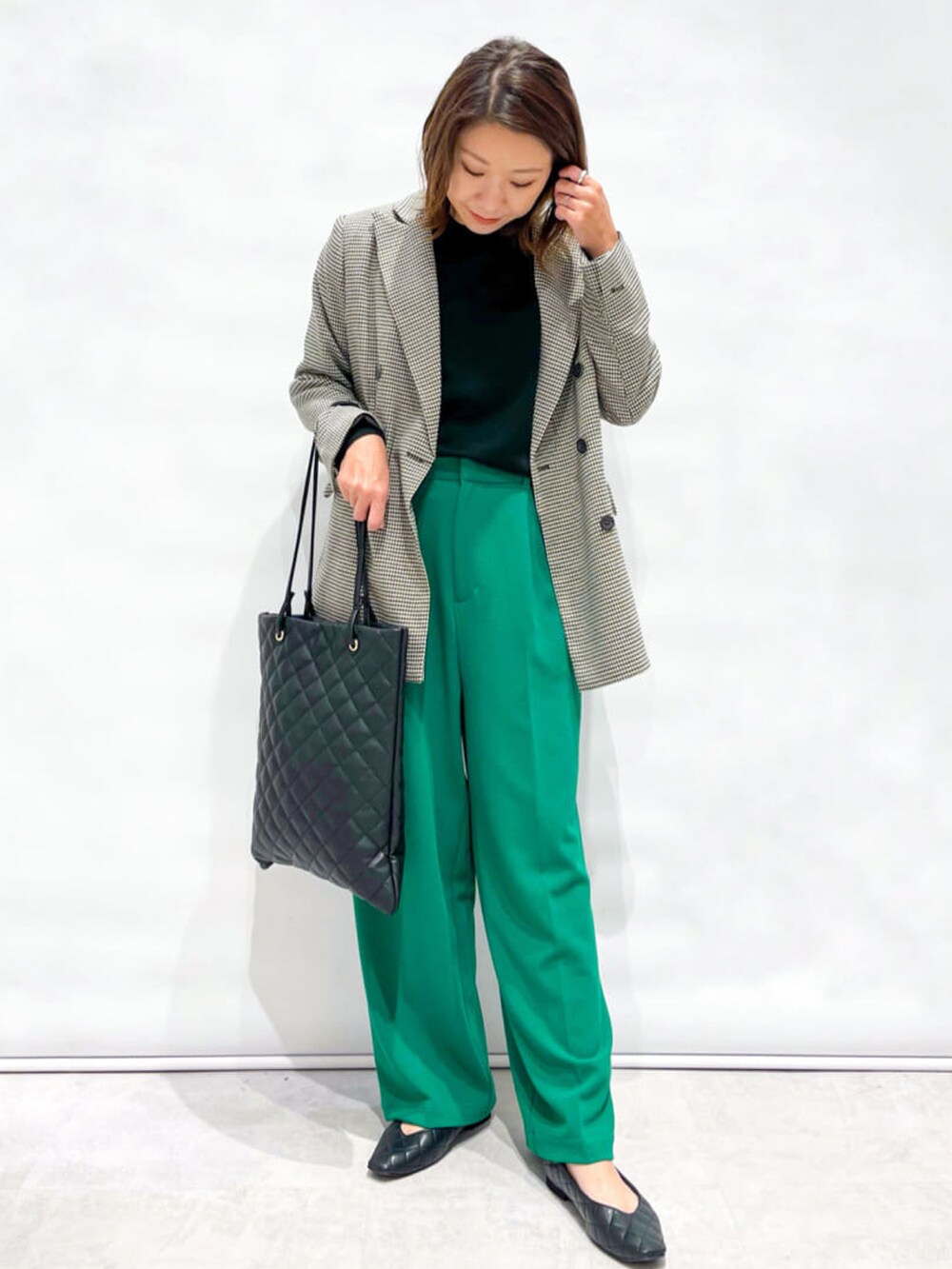 ベージュ系のテーラードジャケット、ブラック系のニット/セーター、ブラック系のパンプスを着用したレディースの秋コーディネートの2枚目の写真