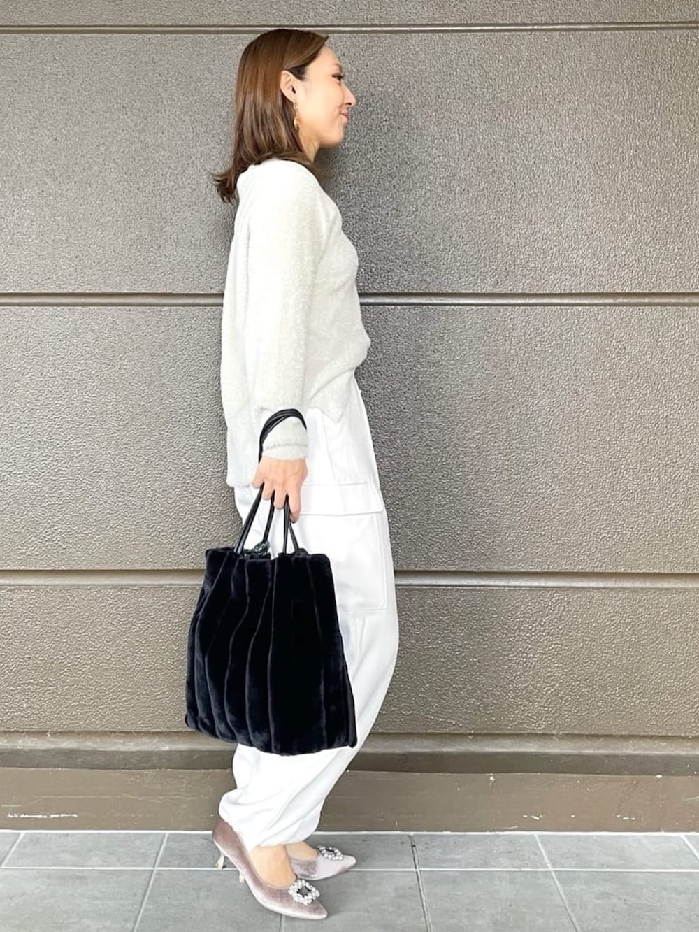 ホワイト系のその他パンツ、ブラック系のショルダーバッグ、ベージュ系のニット/セーターを着用したレディースの冬コーディネートの3枚目の写真