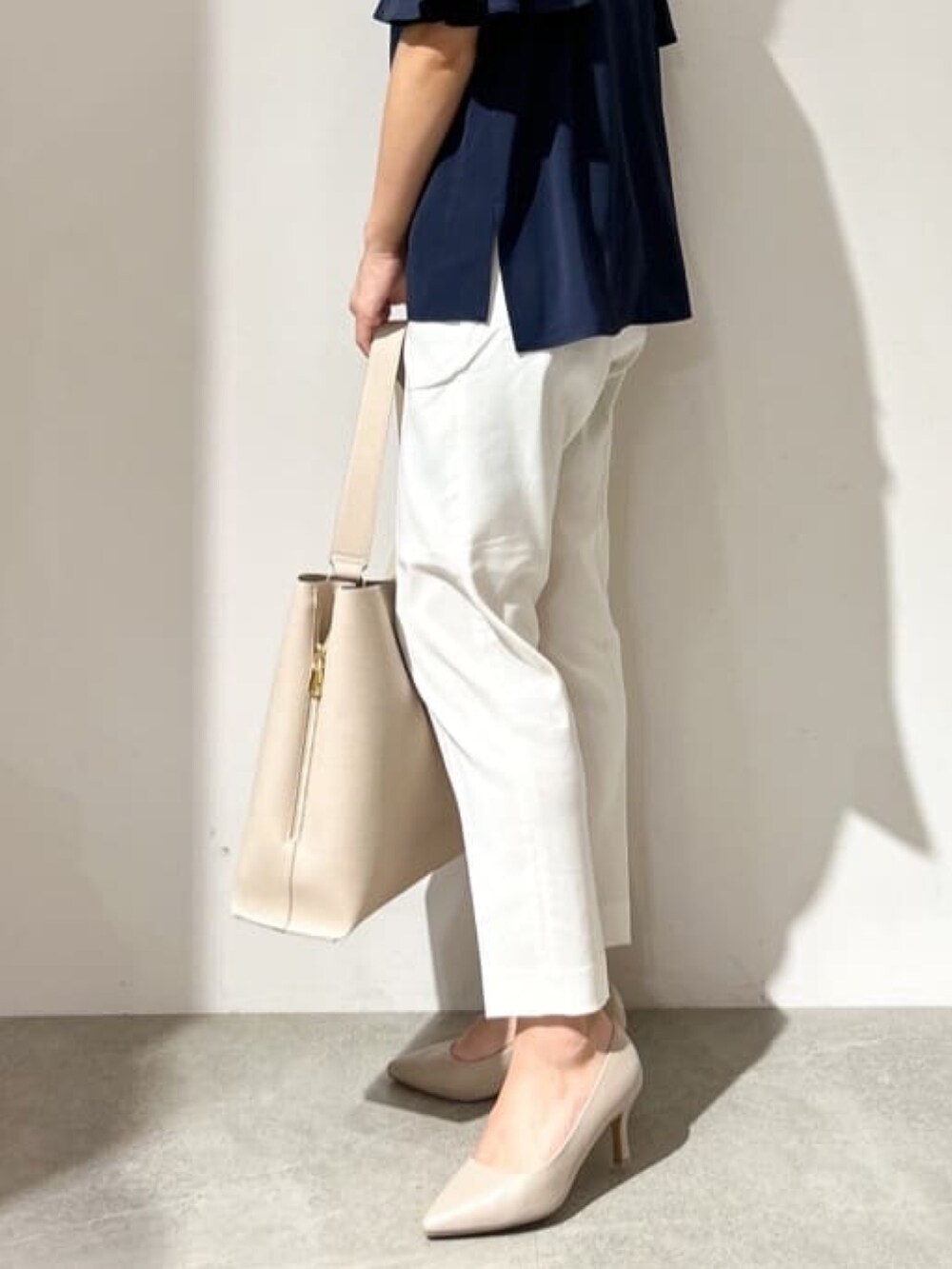 ブルー系のシャツ/ブラウス、ホワイト系のその他パンツ、ベージュ系のショルダーバッグを着用したレディースの夏コーディネートの6枚目の写真