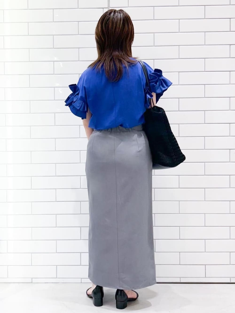 ブルー系のTシャツ/カットソー、ブラック系のサンダル、グレー系のスカートを着用したレディースの夏コーディネートの3枚目の写真