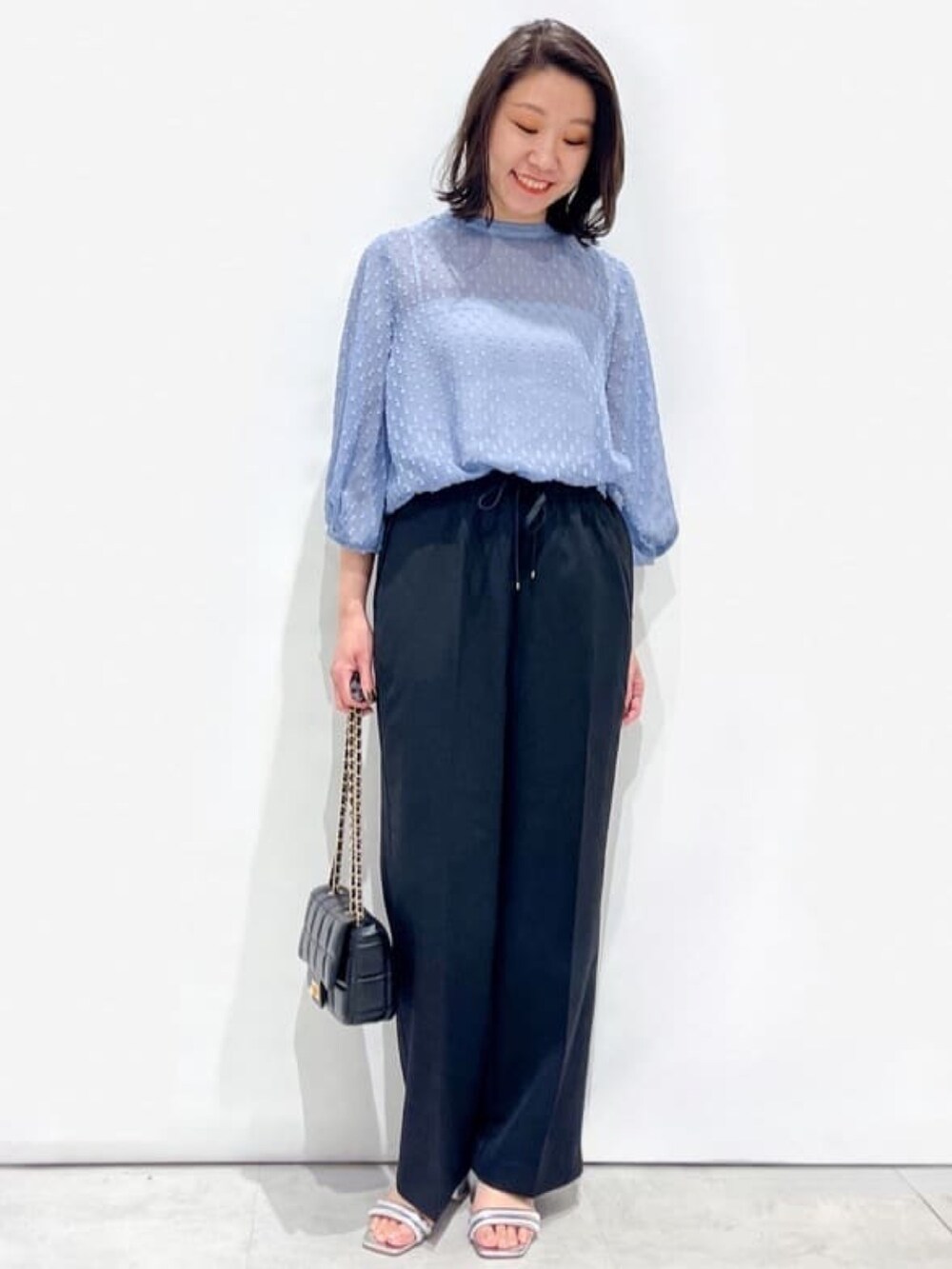 ブラック系のその他パンツ、ブルー系のシャツ/ブラウス、シルバー系のサンダルを着用したレディースの春コーディネートの2枚目の写真