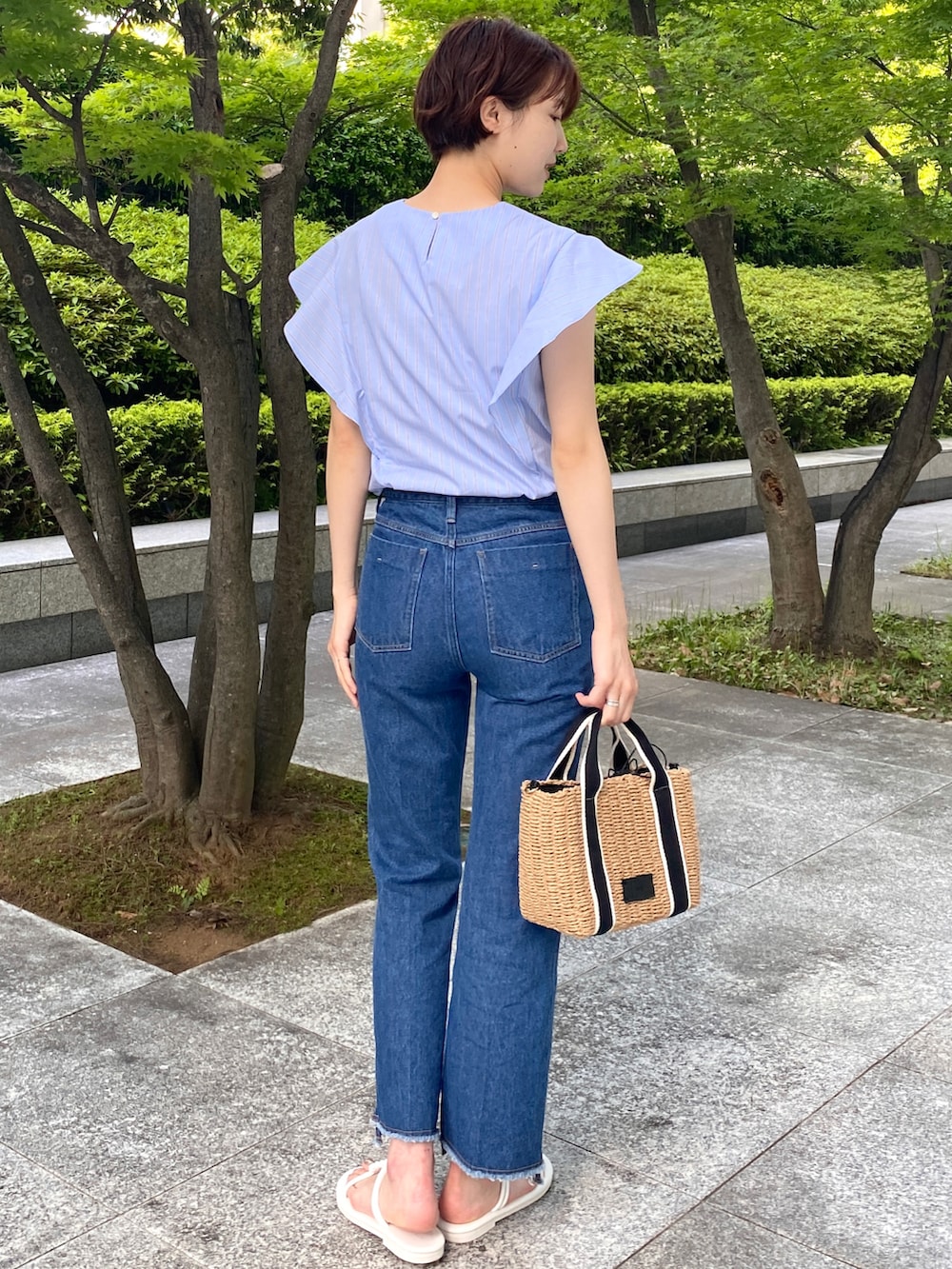 ブルー系のシャツ/ブラウス、ブルー系のデニムパンツ、ブラック系のトートバッグを着用したレディースの夏コーディネートの2枚目の写真