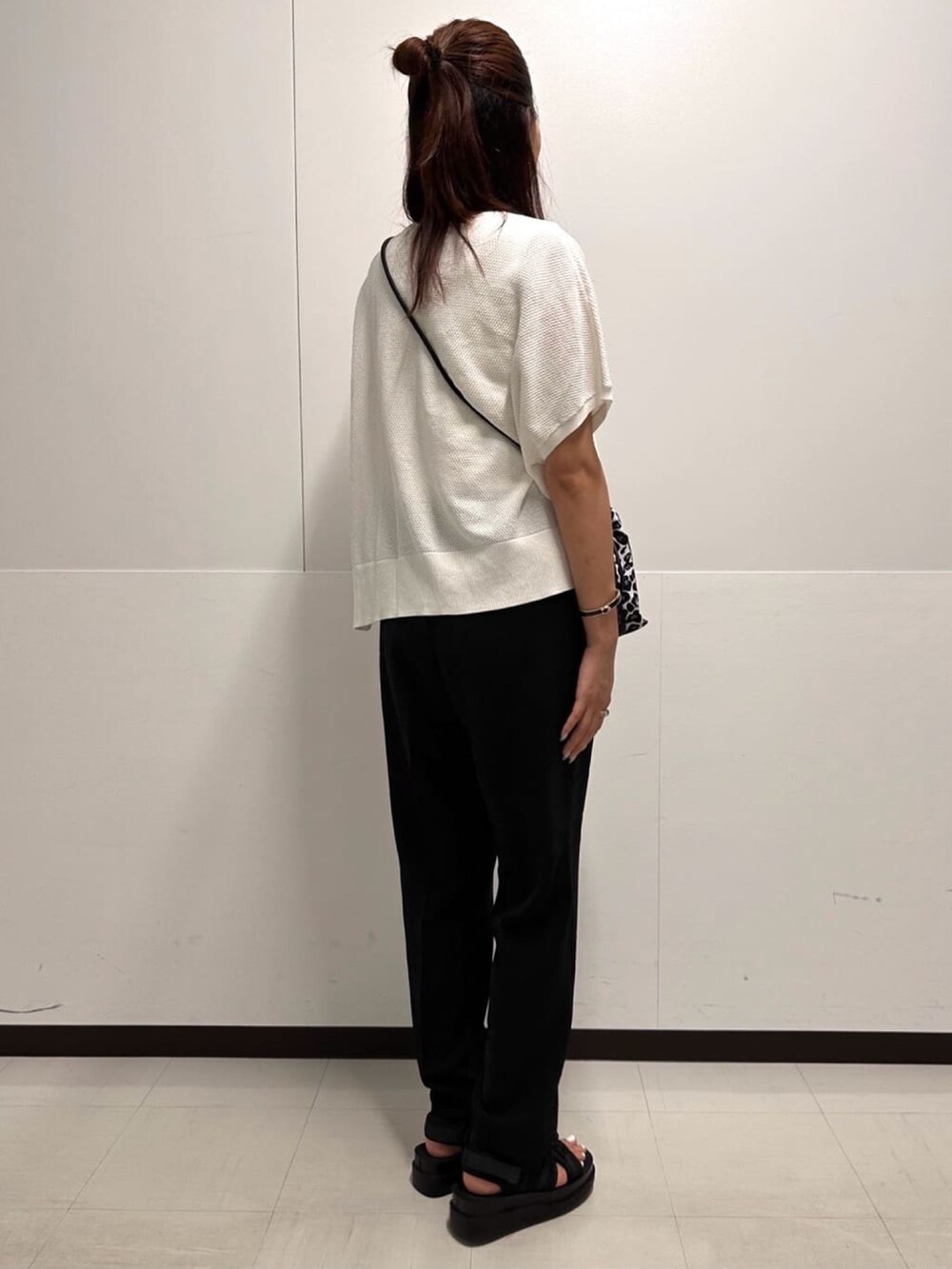 ホワイト系のショルダーバッグ、ブラック系のその他パンツ、ブラック系のサンダルを着用したレディースの夏コーディネートの3枚目の写真