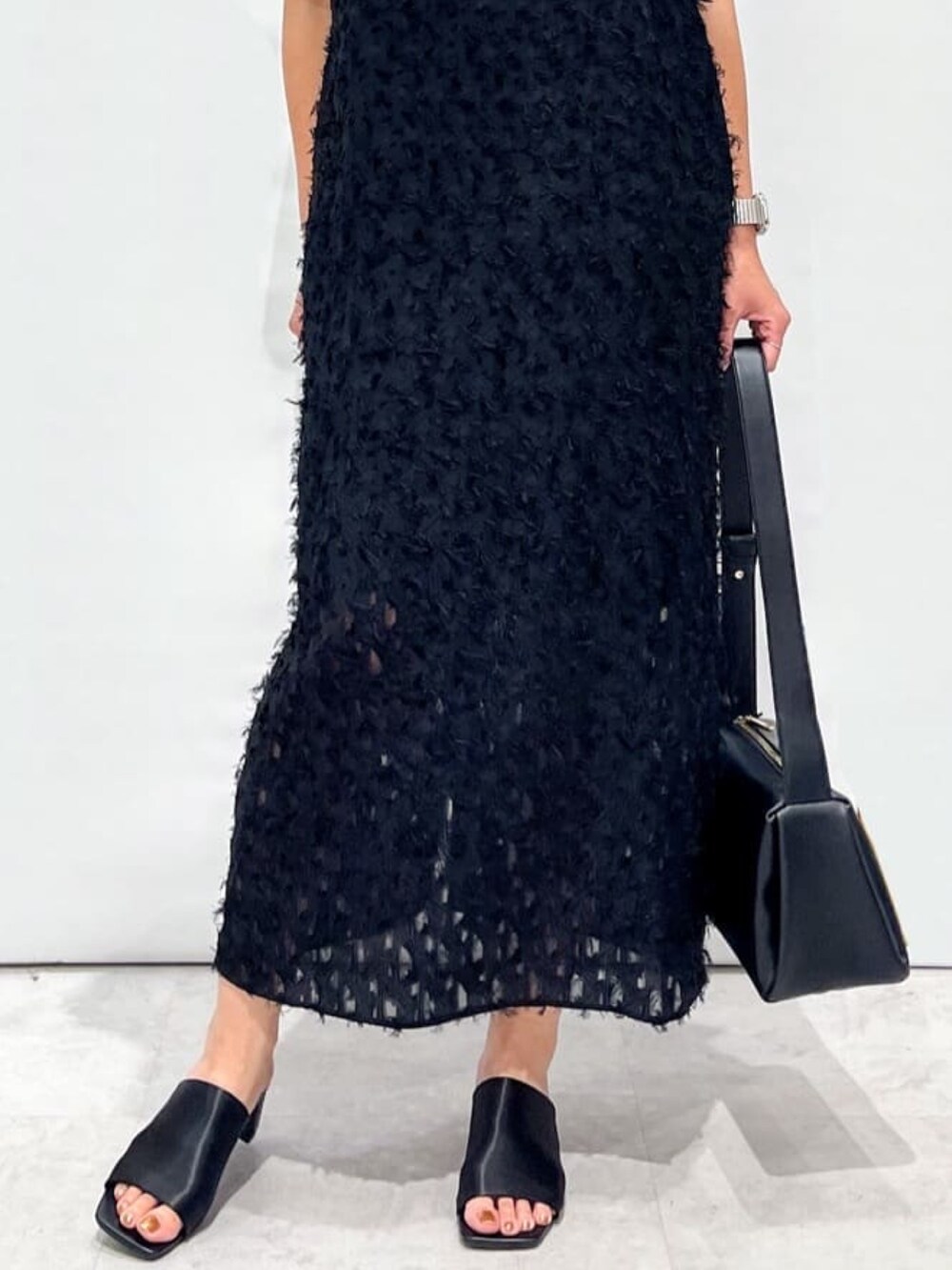 ブラック系のサンダル、ブラック系のショルダーバッグ、ブラック系のワンピースを着用したレディースの夏コーディネートの9枚目の写真