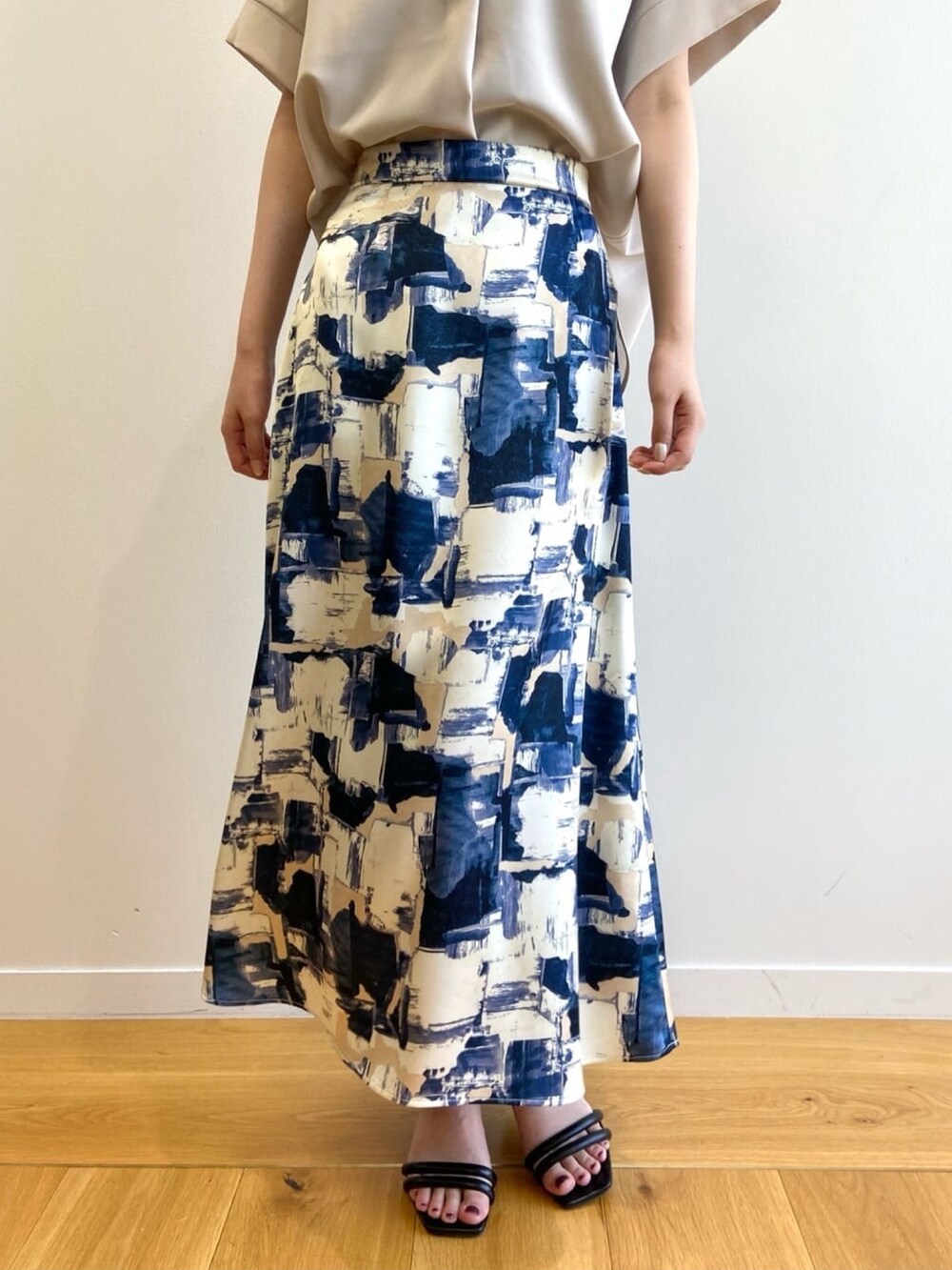 ベージュ系のシャツ/ブラウス、ブルー系のスカート、ブラック系のサンダルを着用したレディースの夏コーディネートの7枚目の写真