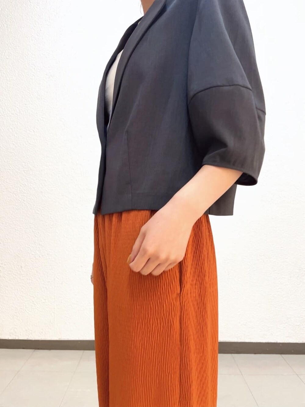 ホワイト系のタンクトップ、グレー系のテーラードジャケット、レッド系のその他パンツを着用したレディースの夏コーディネートの3枚目の写真