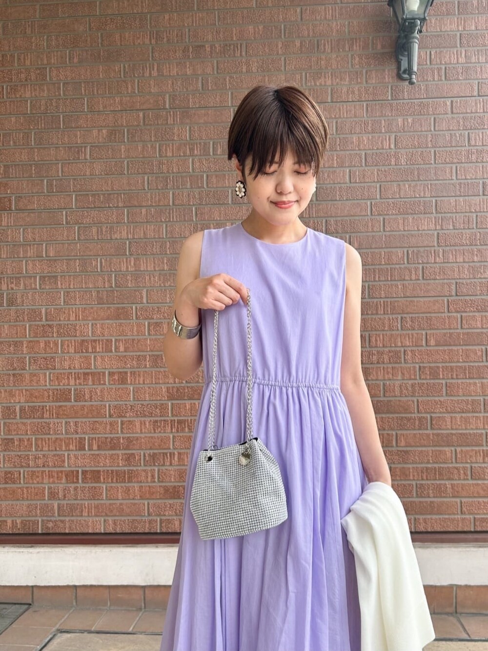 ホワイト系のカーディガン/ボレロ、パープル系のワンピース、ホワイト系のショルダーバッグを着用したレディースの夏コーディネートの6枚目の写真