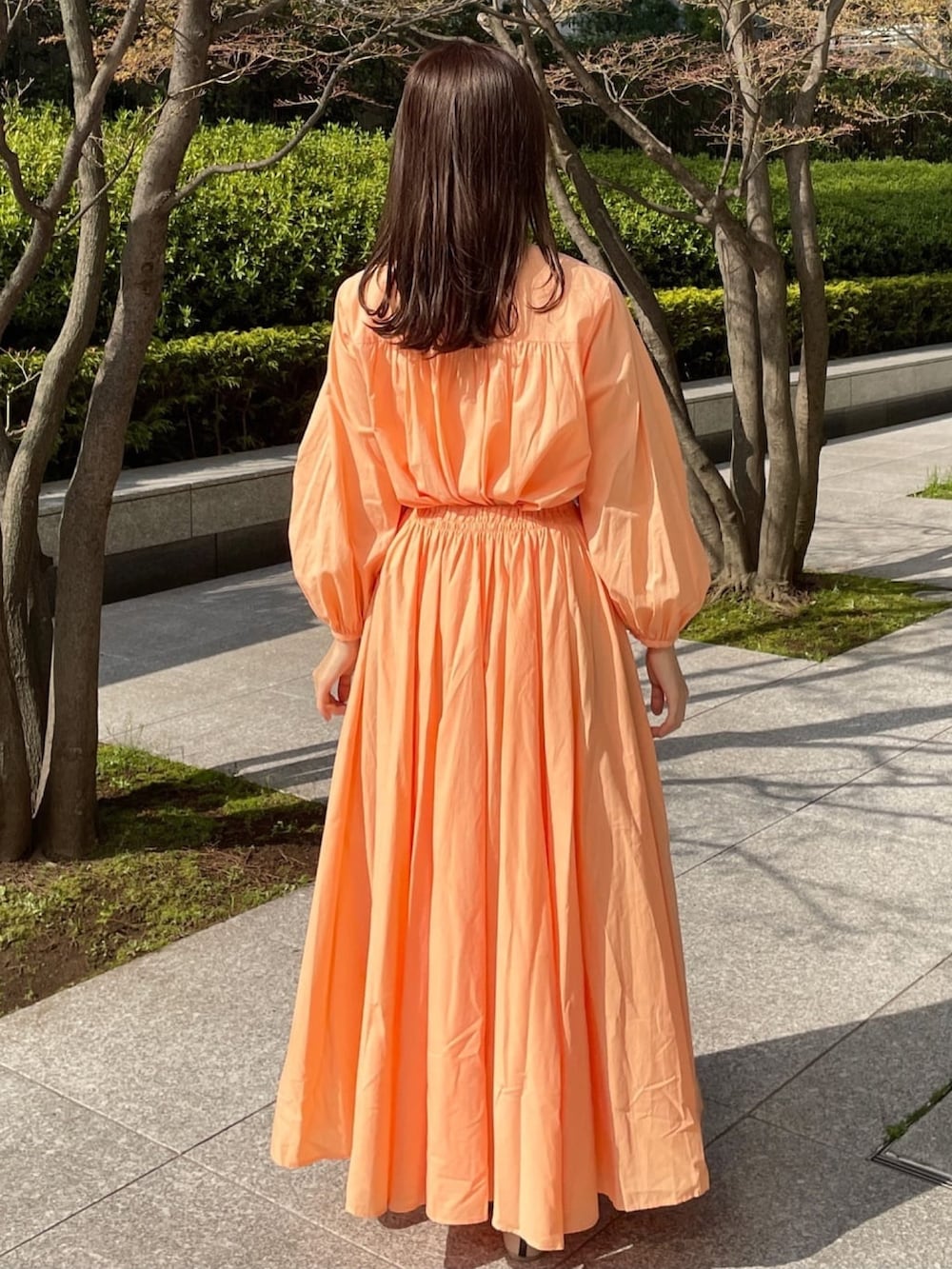 オレンジ系のシャツ/ブラウス、オレンジ系のスカート、ベージュ系のその他シューズを着用したレディースの春コーディネートの2枚目の写真