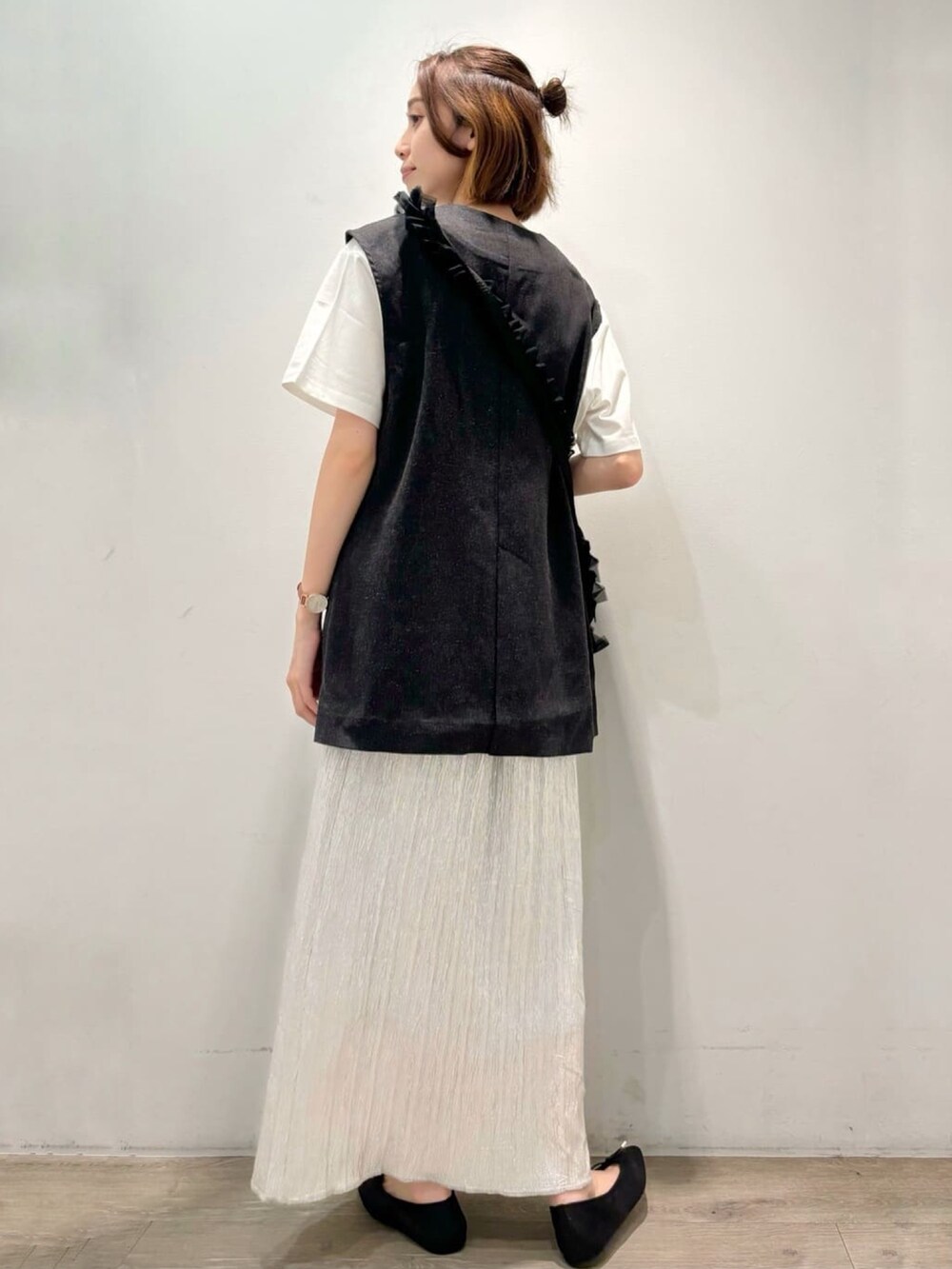 シルバー系のスカート、グレー系のベスト、ホワイト系のTシャツ/カットソーを着用したレディースの夏コーディネートの4枚目の写真