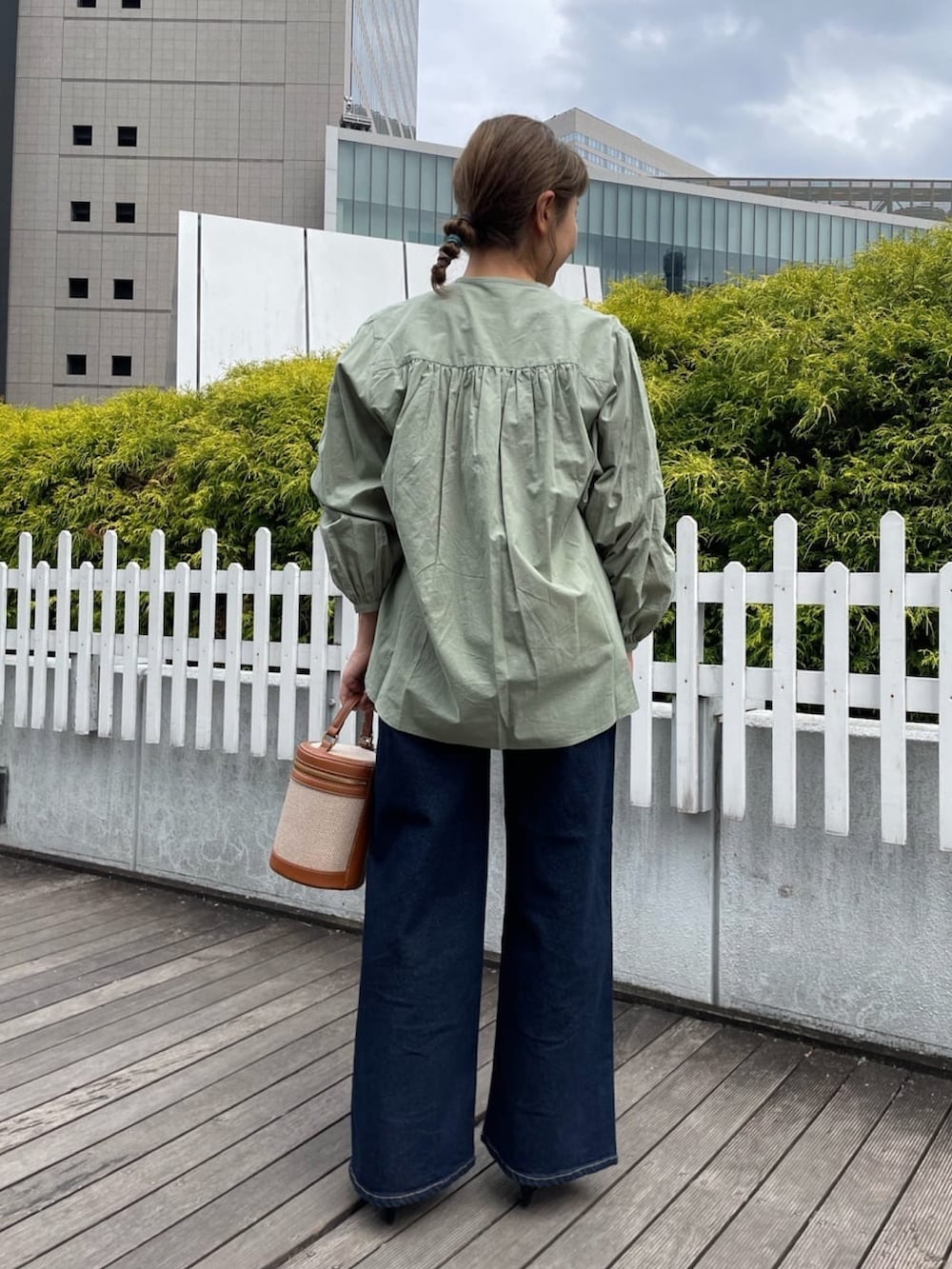 グリーン系のシャツ/ブラウス、ブルー系のデニムパンツ、ブラウン系のショルダーバッグを着用したレディースの春コーディネートの4枚目の写真