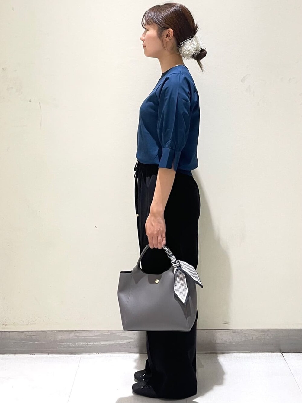 ブルー系のニット/セーター、ブラック系のその他パンツ、グレー系のトートバッグを着用したレディースの夏コーディネートの3枚目の写真