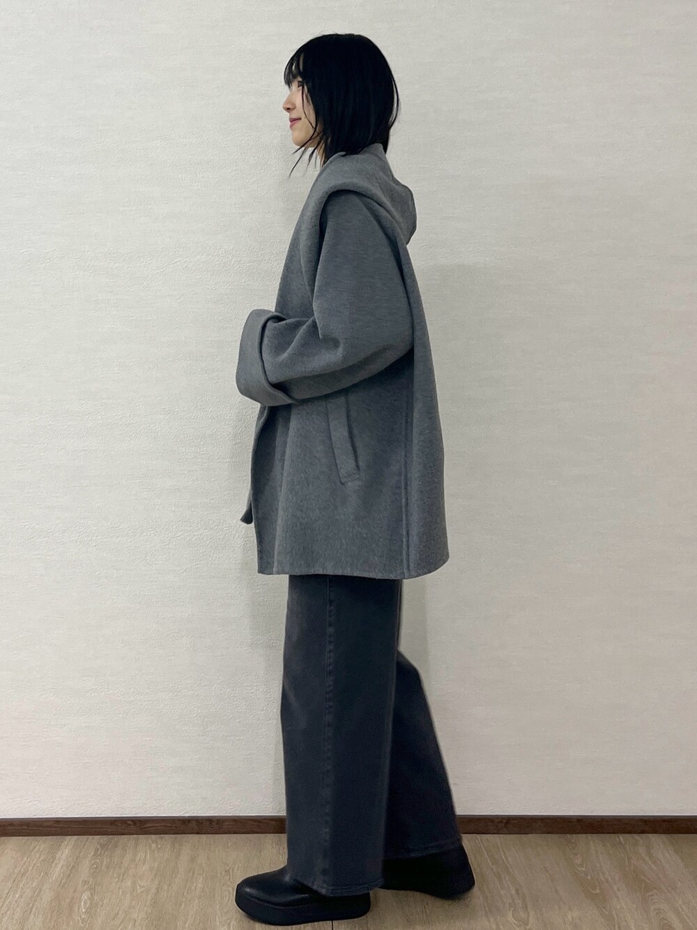 ホワイト系のニット/セーター、グレー系のその他アウター、ブラック系のショルダーバッグを着用したレディースの冬コーディネートの3枚目の写真