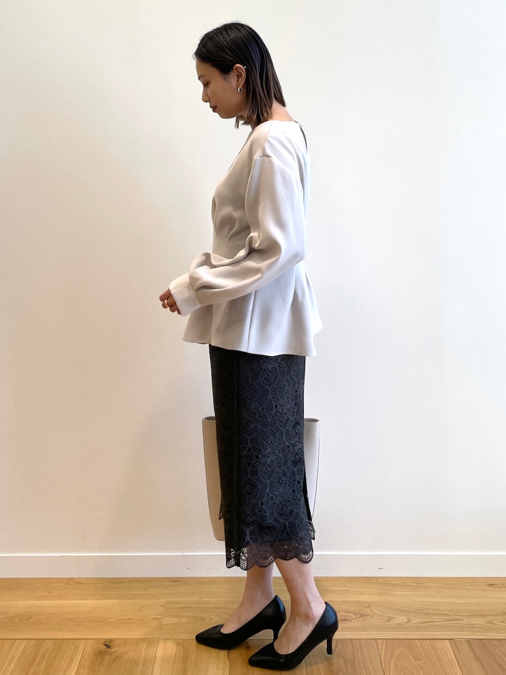 グレー系のシャツ/ブラウス、グレー系のスカート、ベージュ系のトートバッグを着用したレディースの冬コーディネートの2枚目の写真