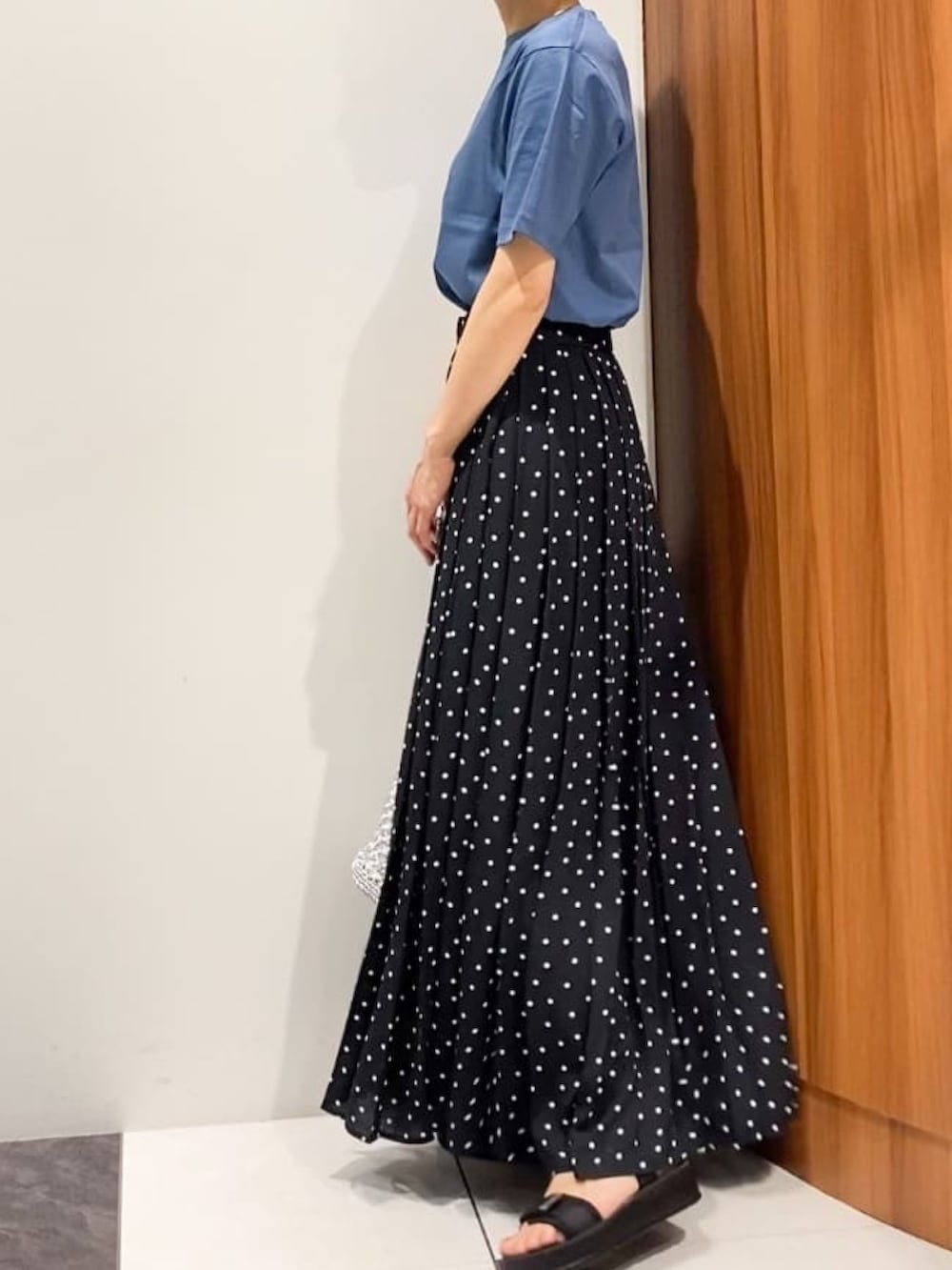 ブラック系のスカート、ブラック系のサンダル、シルバー系のトートバッグを着用したレディースの夏コーディネートの3枚目の写真