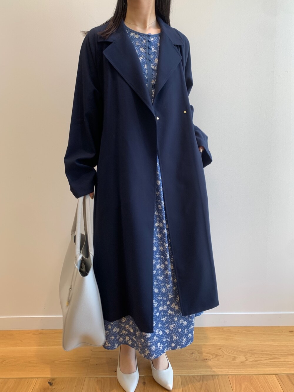 ブルー系のトレンチコート、ブルー系のワンピース、グレー系のトートバッグを着用したレディースの春コーディネートの5枚目の写真