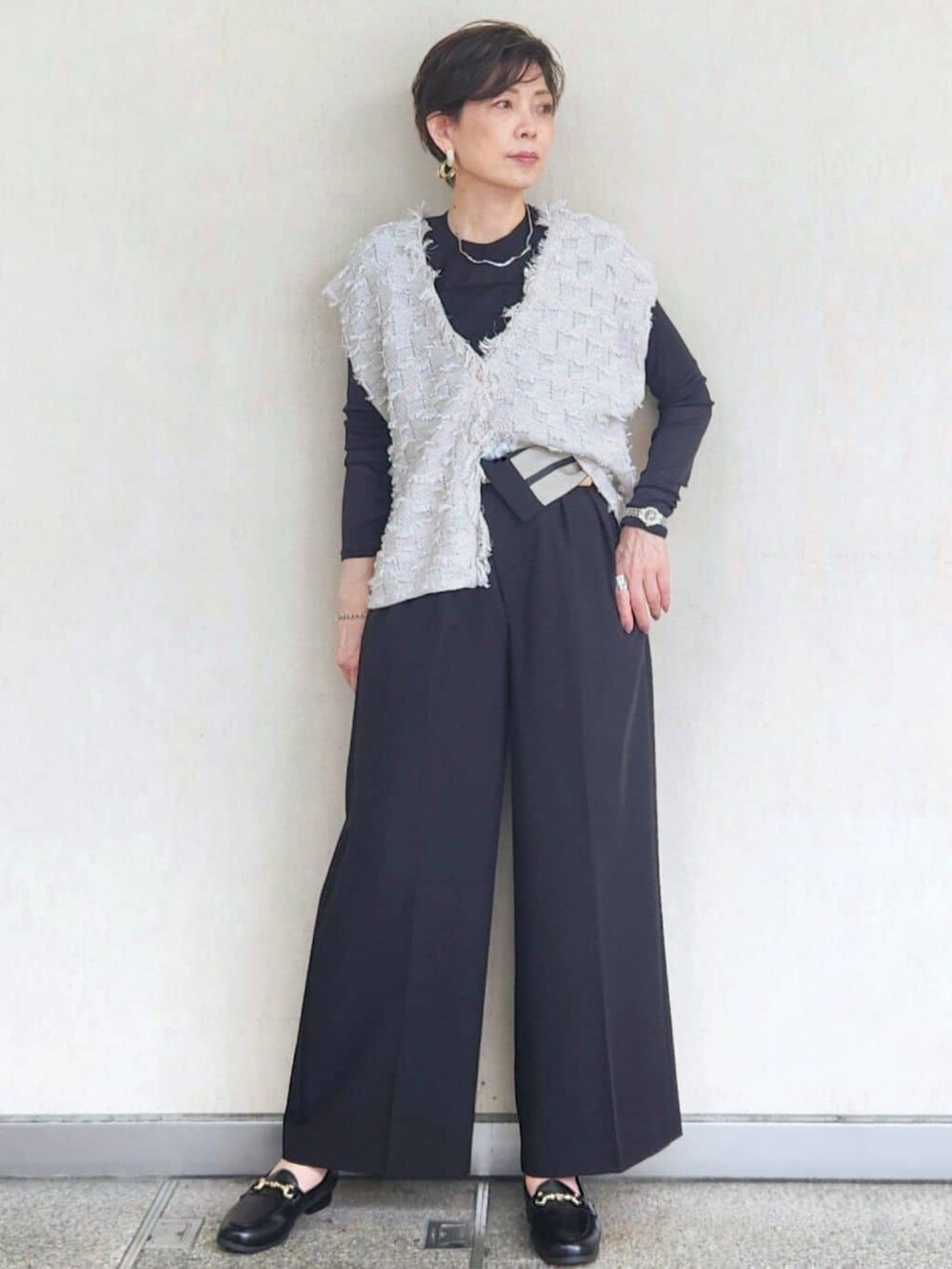 グレー系のニット/セーター、ブラック系のTシャツ/カットソー、ブラック系のその他パンツを着用したレディースの秋コーディネートの2枚目の写真