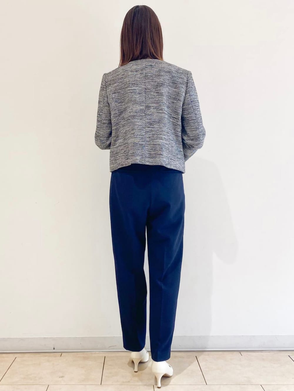 ホワイト系のパンプス、ブラック系のスーツジャケット、ブルー系のスーツパンツを着用したレディースの春コーディネートの3枚目の写真