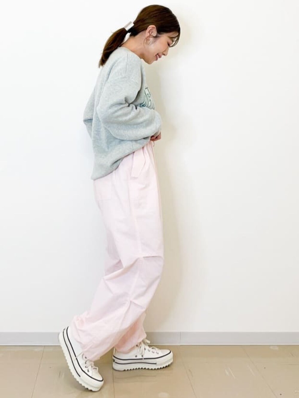 グレー系のニット/セーター、ピンク系のその他パンツを着用したレディースの春コーディネートの2枚目の写真