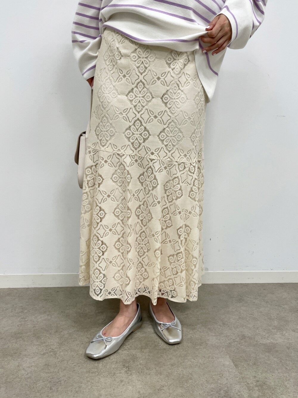 パープル系のニット/セーター、ホワイト系のスカート、ホワイト系のショルダーバッグを着用したレディースの冬コーディネートの4枚目の写真