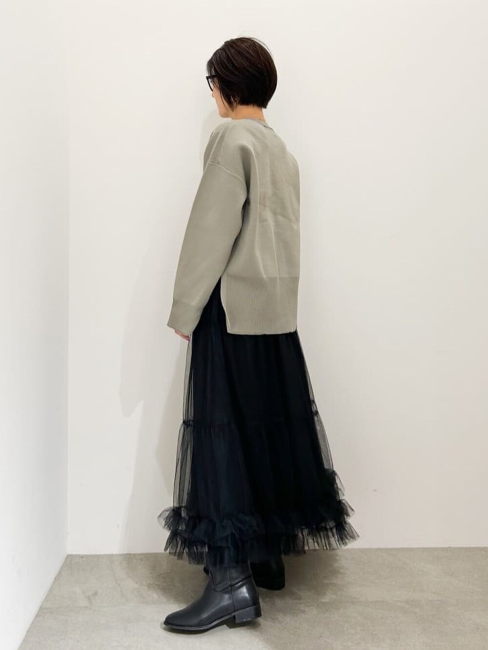 ブラック系のスカート、グレー系のニット/セーターを着用したレディースの冬コーディネートの2枚目の写真