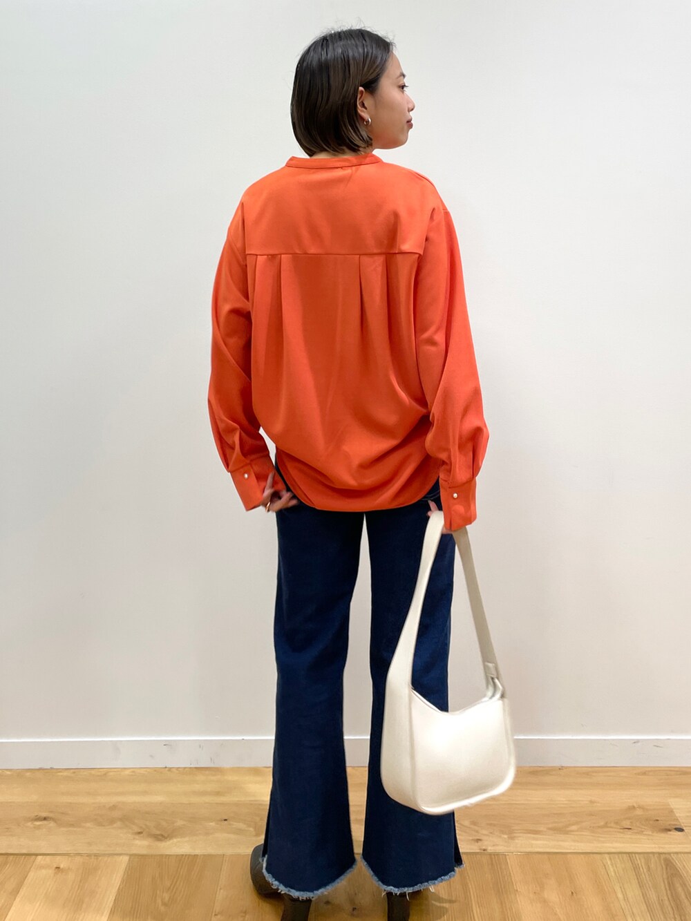 オレンジ系のTシャツ/カットソー、ブルー系のその他パンツ、ブラック系のブーツを着用したレディースの秋コーディネートの3枚目の写真