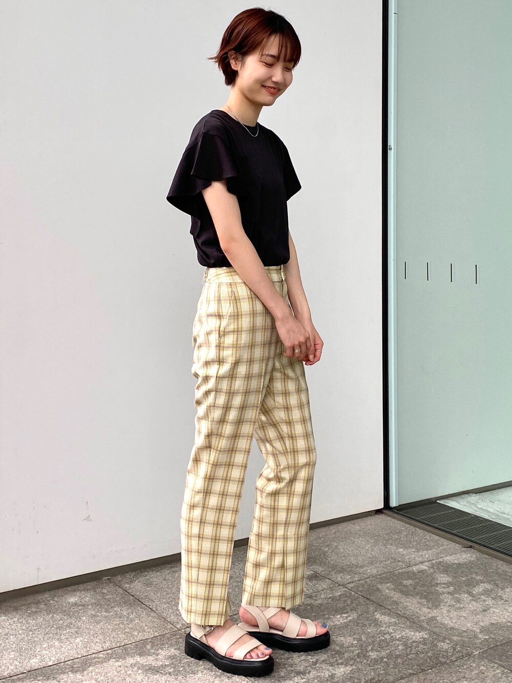ブラック系のTシャツ/カットソー、イエロー系のその他パンツ、ホワイト系のサンダルを着用したレディースの夏コーディネートの2枚目の写真