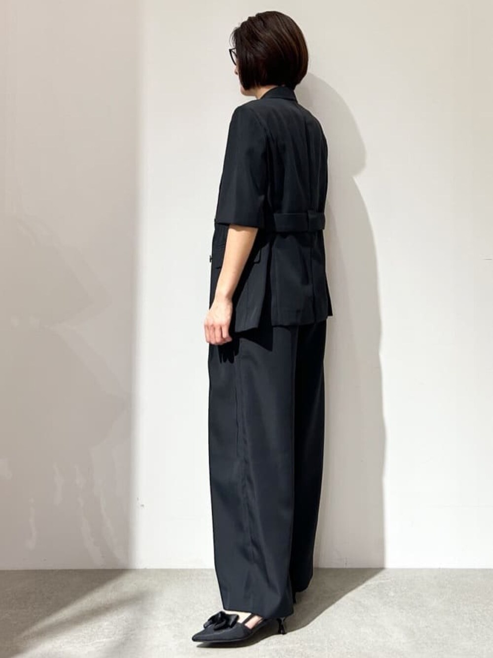 ブラック系のその他パンツ、ブラック系のパンプス、ブラック系のテーラードジャケットを着用したレディースの春コーディネートの5枚目の写真