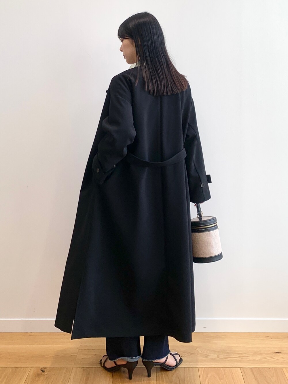 ブラック系のステンカラーコート、グリーン系のシャツ/ブラウス、ブルー系のデニムパンツを着用したレディースの春コーディネートの3枚目の写真