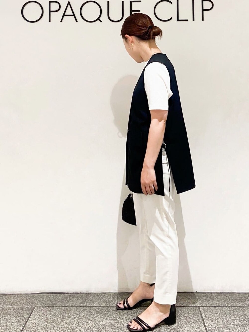 ホワイト系のTシャツ/カットソー、ブラック系のベスト、ブラック系のショルダーバッグを着用したレディースの夏コーディネートの4枚目の写真